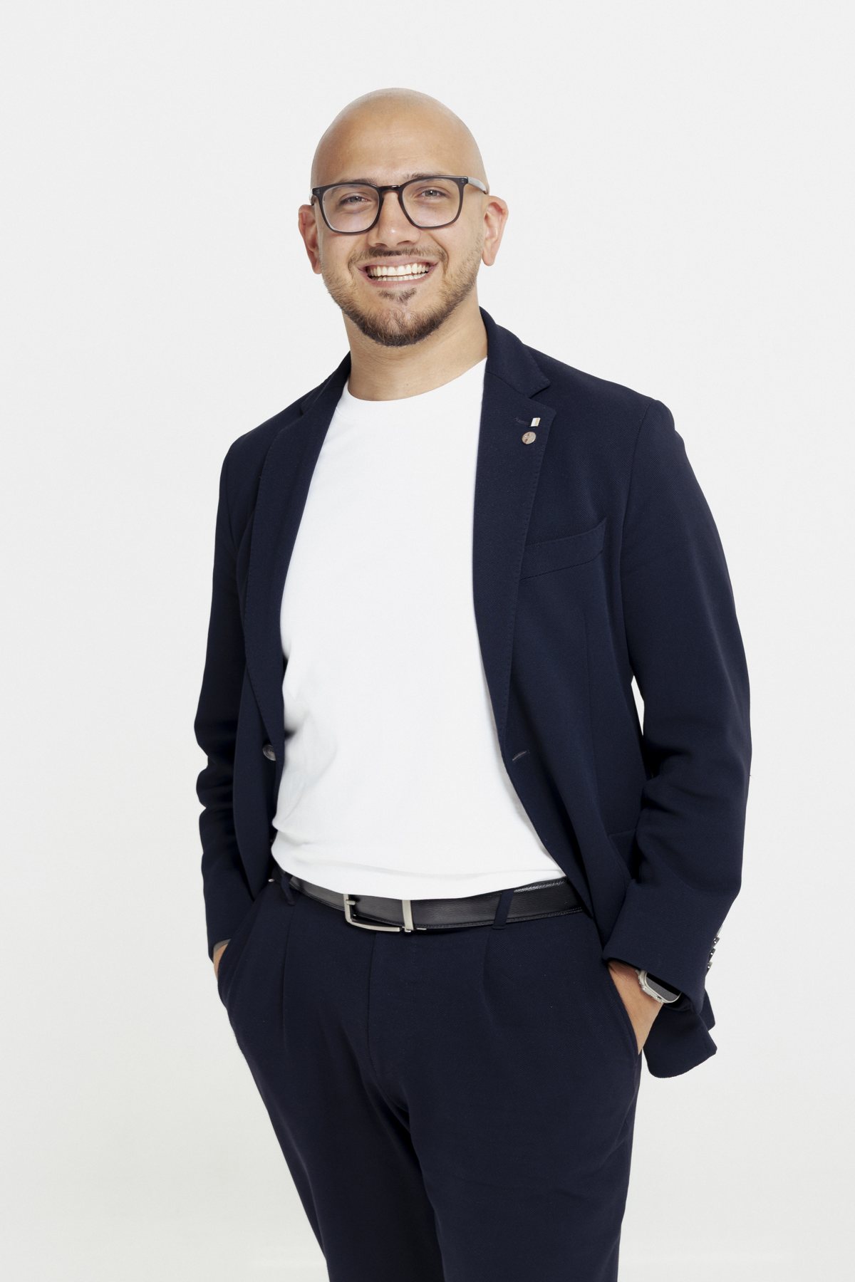 Marco Ancora im dunkelblauen Sakko vor hellem Hintergrund